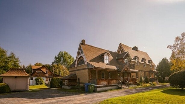 A large, multi-story house with a prominent gabled roof and a front porch. - Maison Du Havre (Petit Duplex) (La Malbaie)