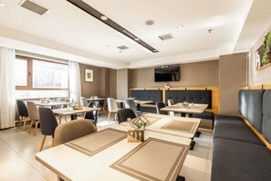 A modern dining area with tables, chairs, and a sofa. - Homeinn Selected Hotel (Shenyang Army General Hospital South Tower Subway Station) (Shenyang)