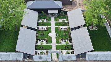 A symmetrical building with a central courtyard, surrounded by trees and a well-maintained lawn.