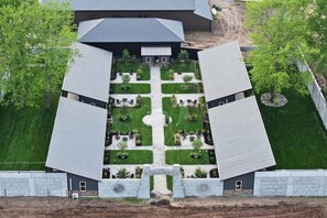 Un bâtiment symétrique doté d’une cour centrale, entouré d’arbres et d’une pelouse bien entretenue.