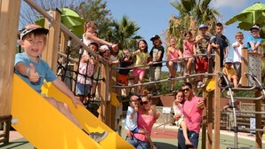 A playground with a yellow slide and climbing structures.