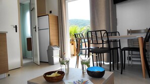 Eine moderne Küche mit Kühlschrank, Mülleimer und Essbereich mit Stühlen und Tisch.