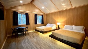 Een kamer met twee bedden, een bureau en een tafel.