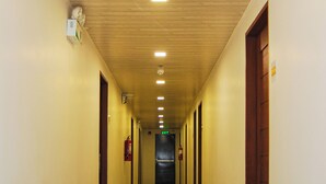A long, narrow hallway with wooden ceiling panels and recessed lighting.