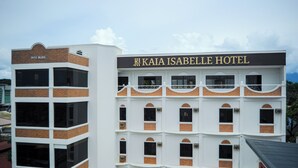 A hotel with a name sign, multiple floors, and a brick facade.