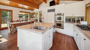 A spacious kitchen with white cabinetry, stainless steel appliances, and a wooden ceiling. - Stunning Peak Views-Spacious Bear Creek 4Bdrm Home (Alpine Meadows)