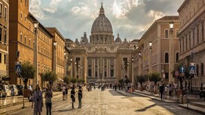 Una calle empedrada que conduce a un gran edificio histórico con una cúpula.