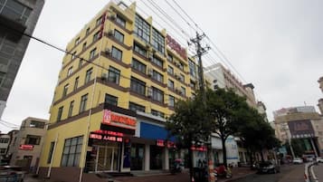 A multi-story building with a commercial ground floor, featuring signage for a restaurant and a shop.