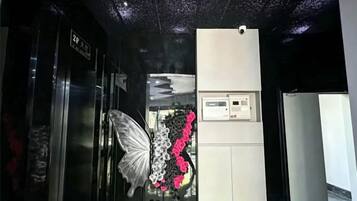 An elevator with a butterfly decoration and a control panel.