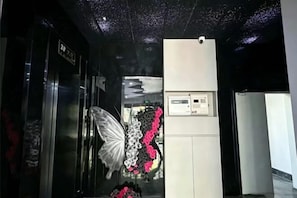 A hotel lobby with a reception desk, a wall-mounted control panel, and a decorative butterfly. - Chongqing Jiayumei Hotel (Chongqing)