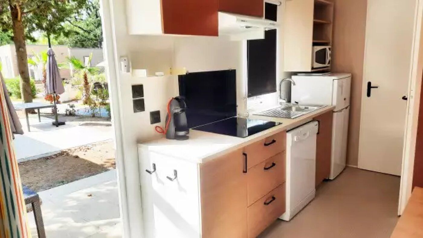 Una cocina compacta con microondas, tostadora y lavamanos.
