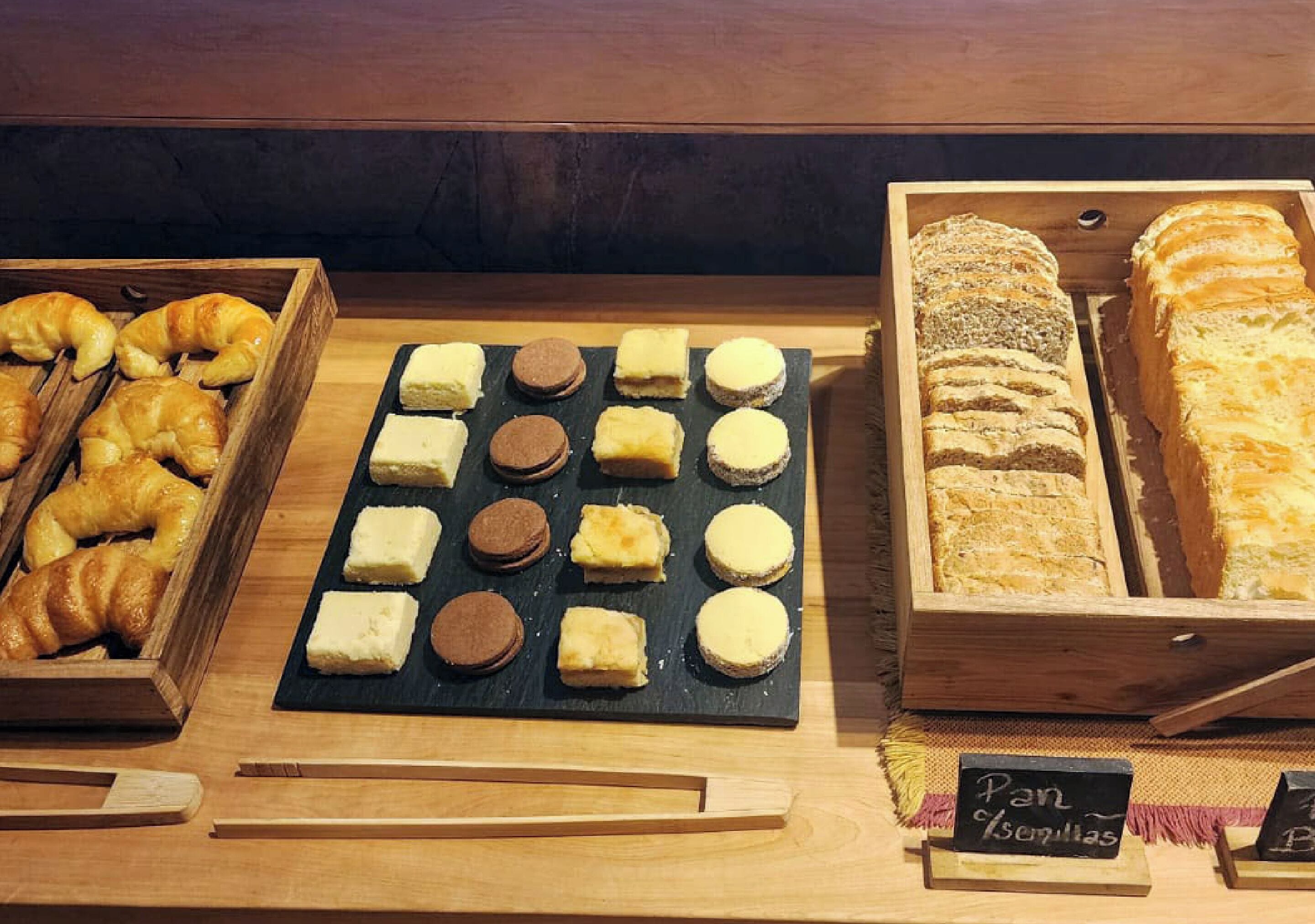 A display of various baked goods including croissants, cookies, and bread.