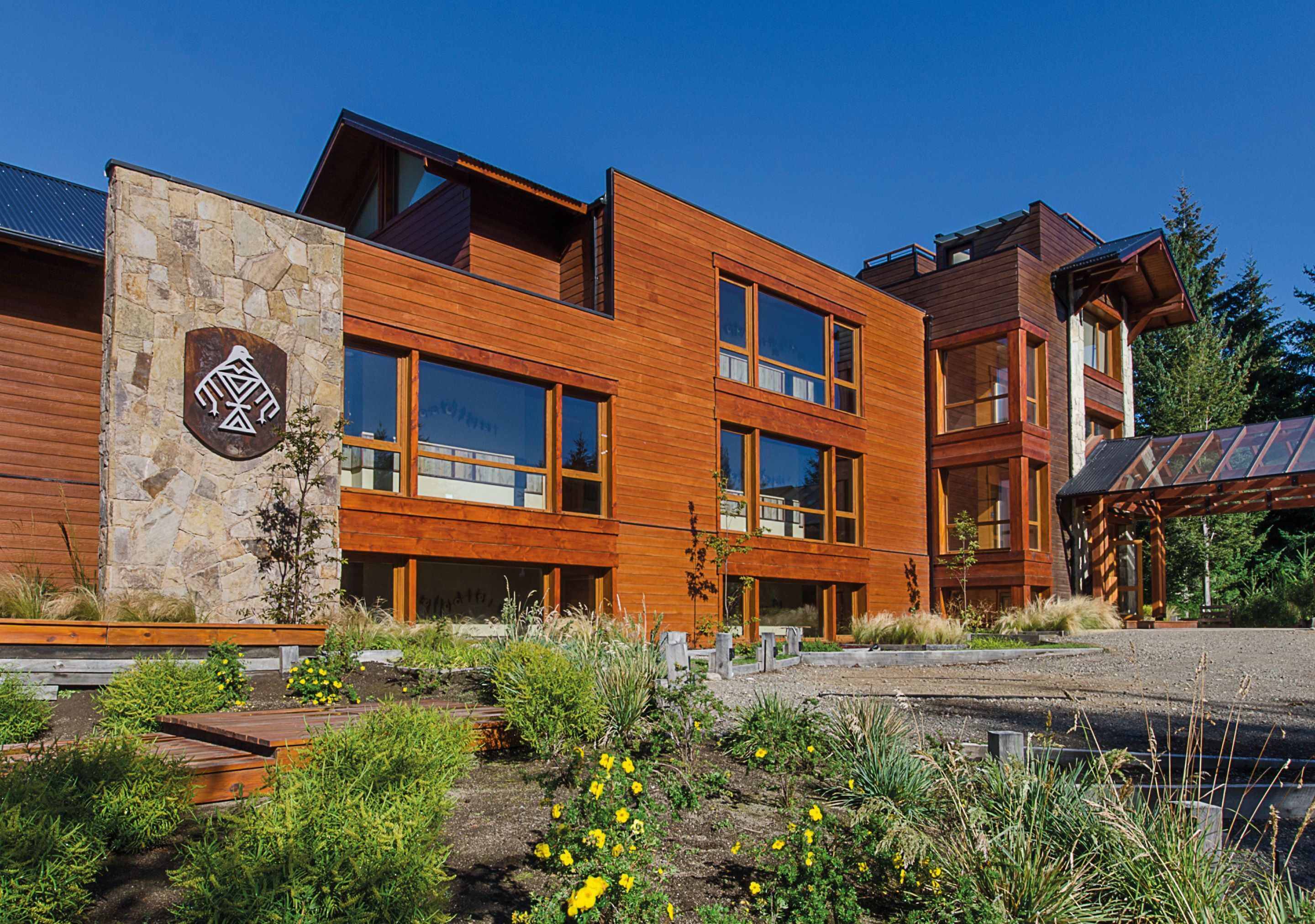 A modern multi-story building with large windows and a stone facade.