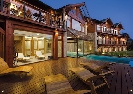 Una piscina techada, una piscina al aire libre, sombrillas