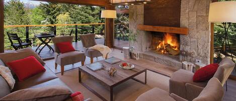 Una sala de estar acogedora con chimenea, asientos cómodos y vistas al exterior.
