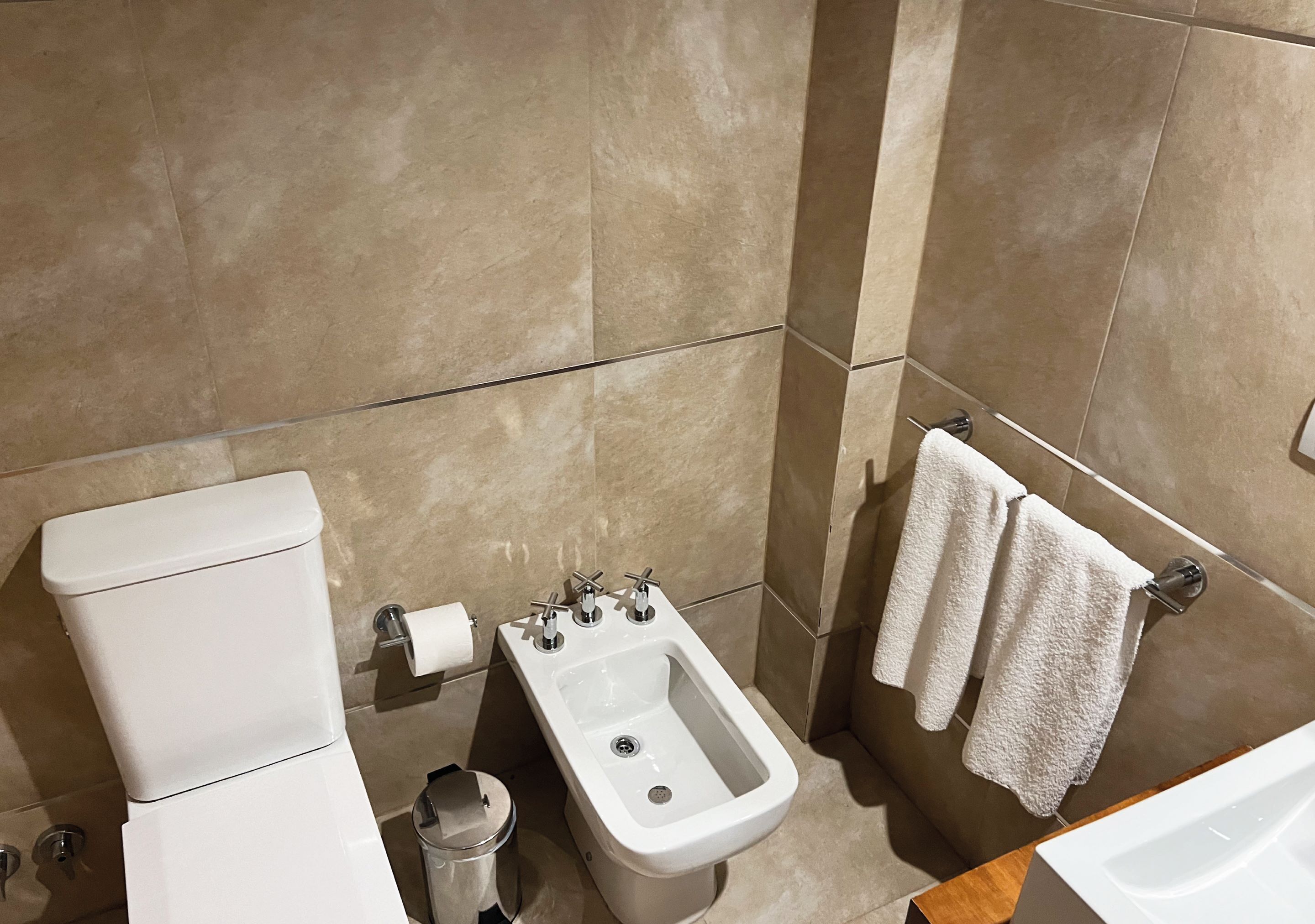 A bathroom with a toilet, bidet, and sink.