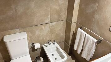 A bathroom with a toilet, bidet, and sink.