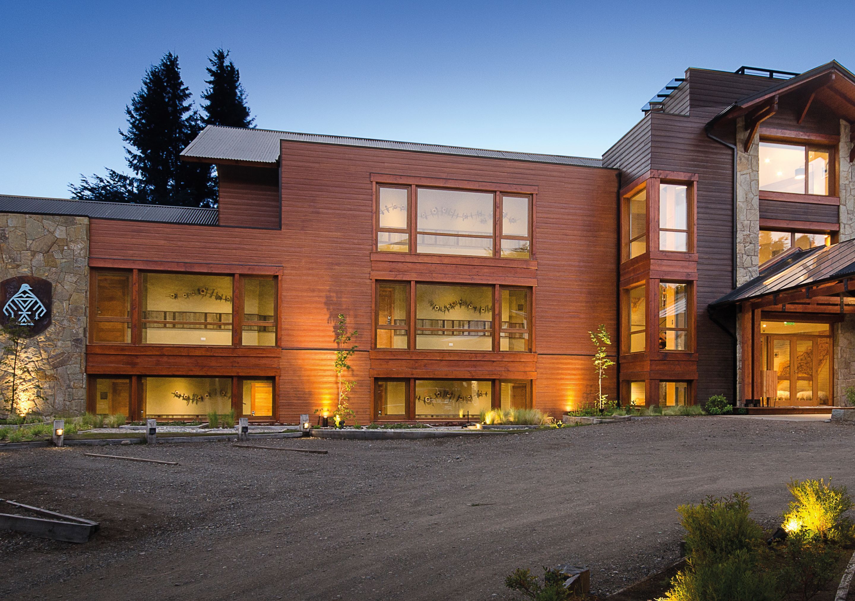 A modern building with large windows, stone walls, and wooden siding.