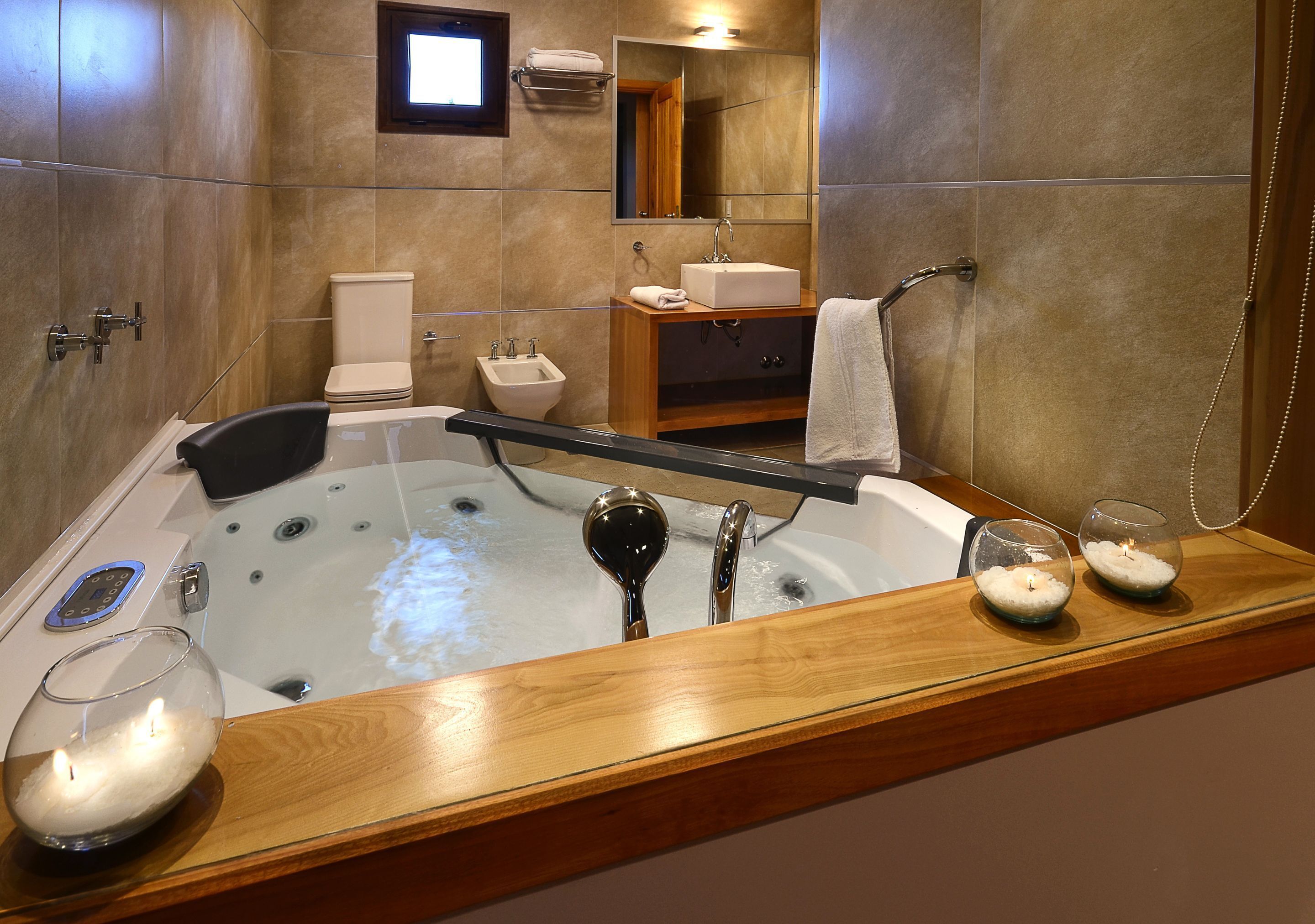 A modern bathroom with a large bathtub, a vanity with a sink, a toilet, and a shower area.