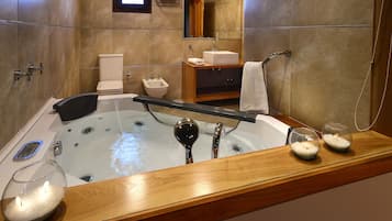 A modern bathroom with a large bathtub, a vanity with a sink, a toilet, and a shower area.