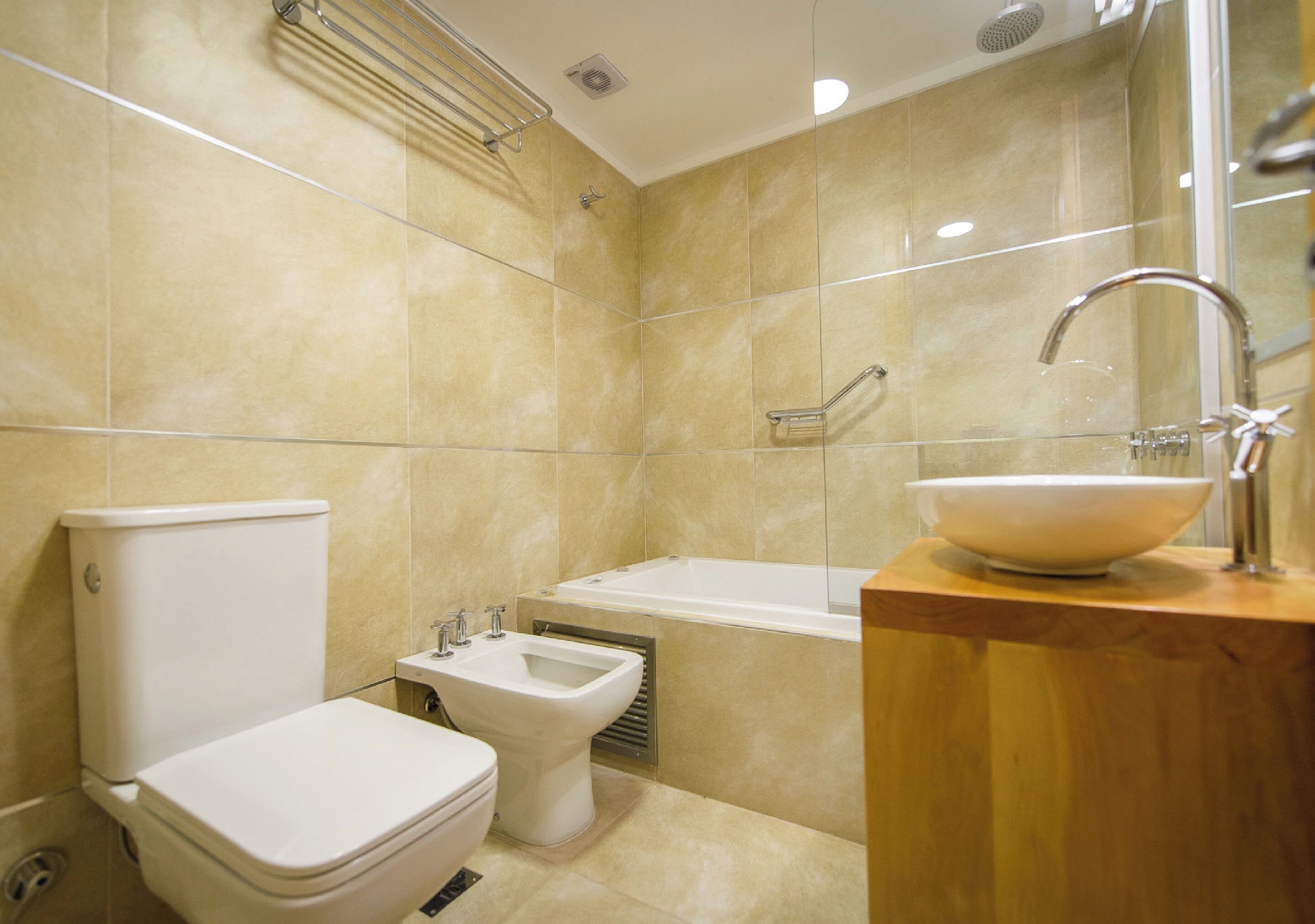 A modern bathroom with a toilet, bidet, and bathtub.