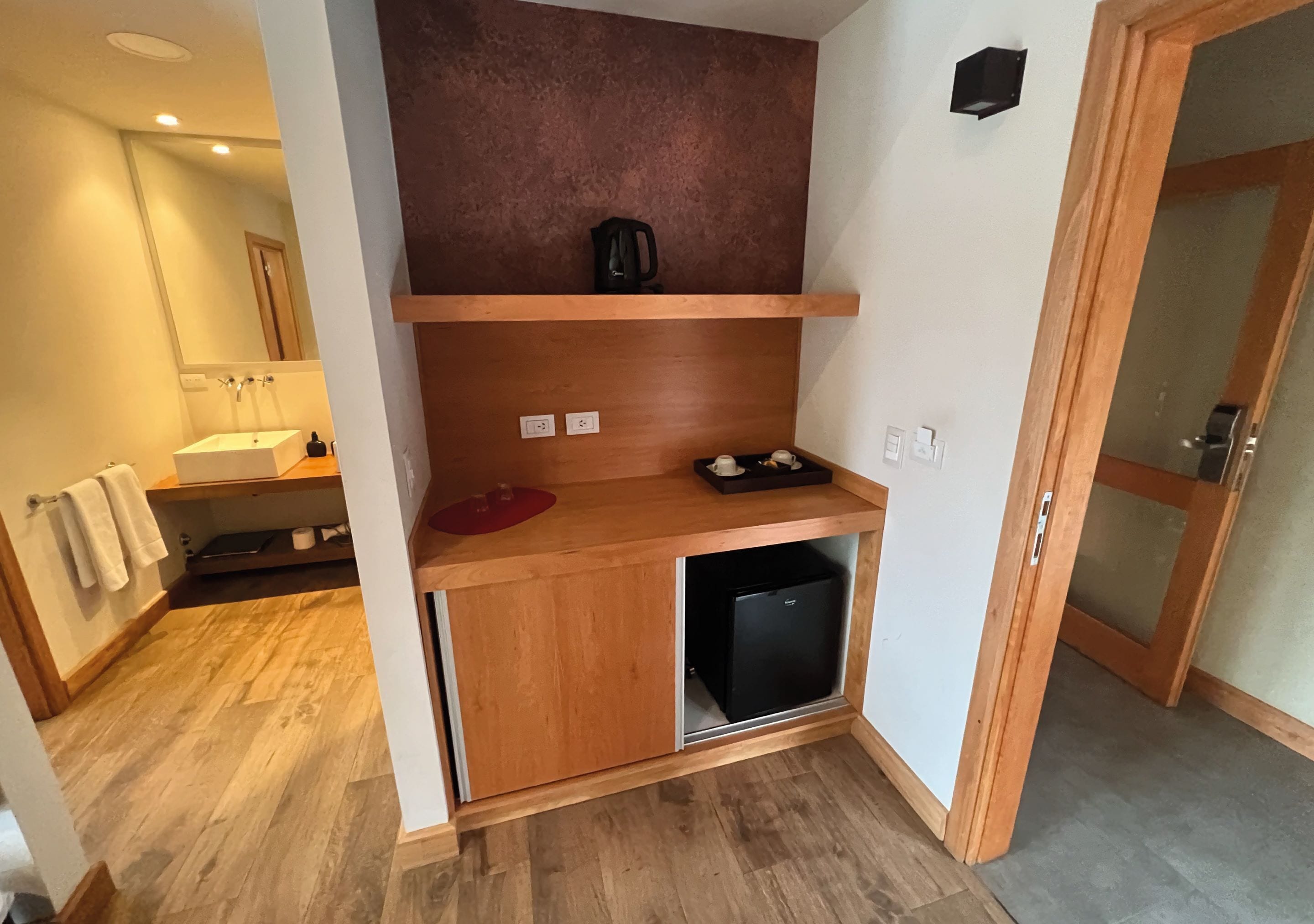 A compact kitchen with a built-in refrigerator, wooden cabinets, and a countertop.