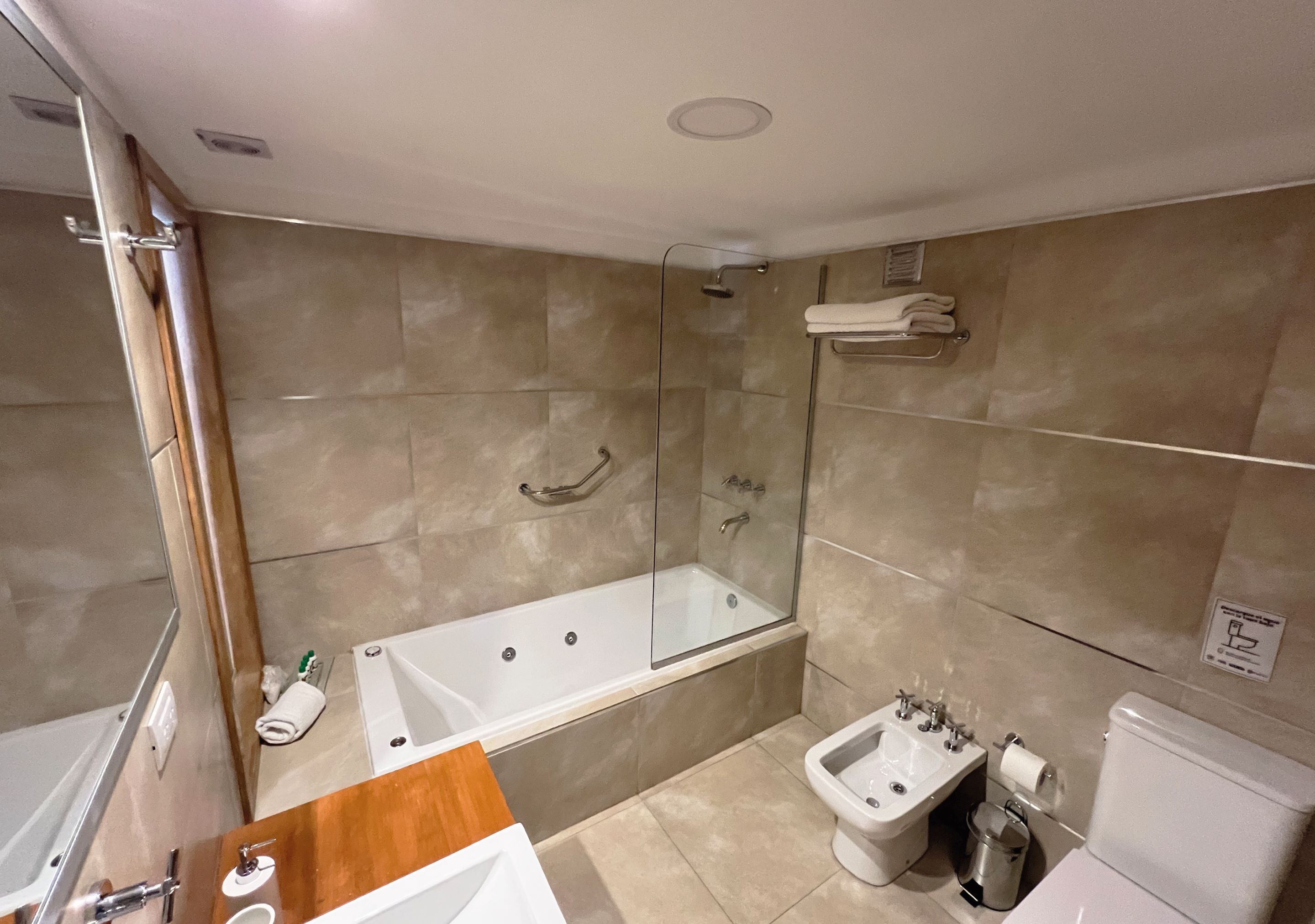 Un baño moderno con ducha envuelta en vidrio, bañera independiente, bidé y retrete.