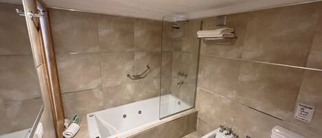 A modern bathroom with a glass-enclosed shower, a freestanding bathtub, a bidet, and a toilet.