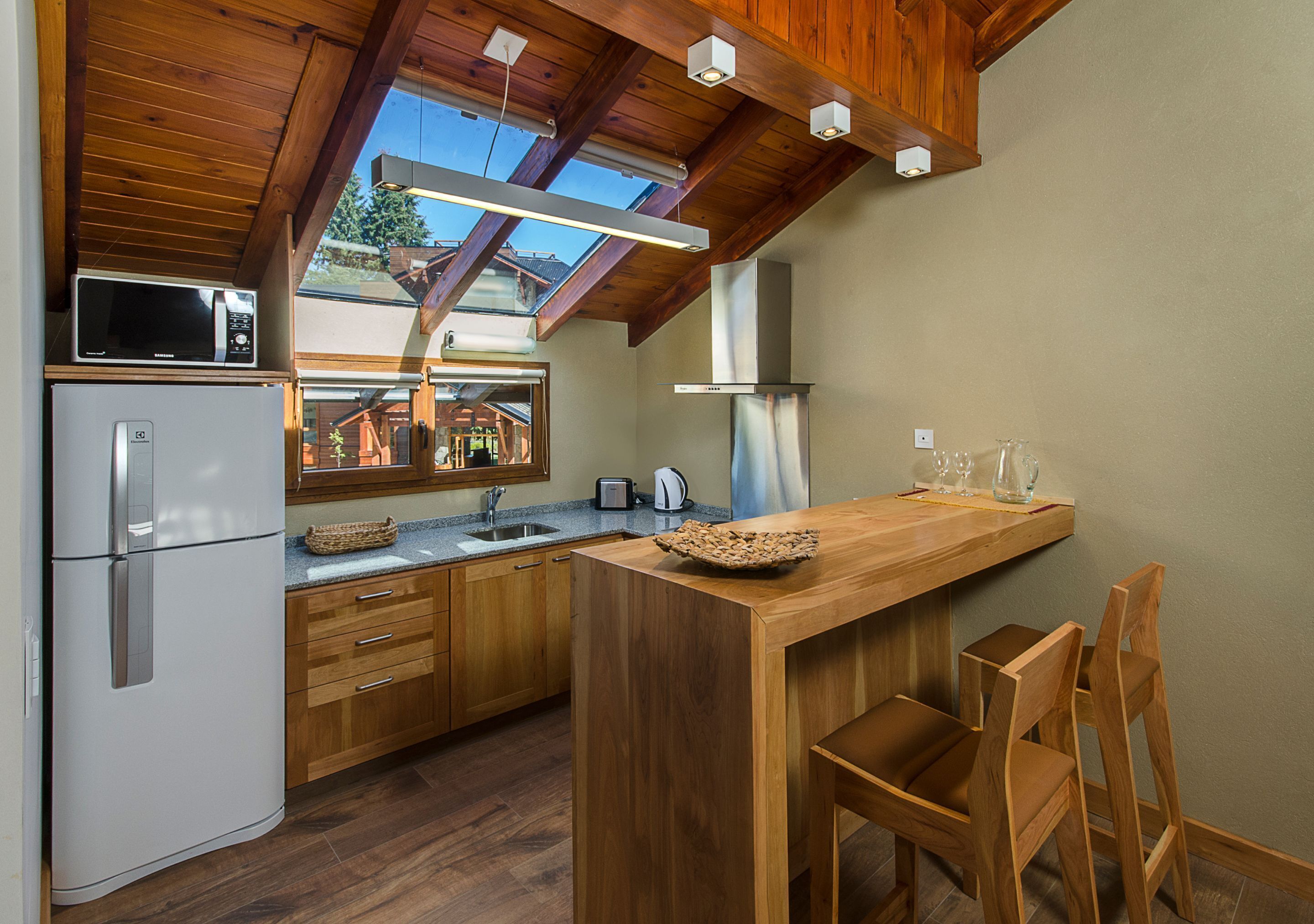 Una cocina moderna con armarios de madera, microondas integrado y una isla grande con asientos.