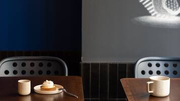 A restaurant interior with two tables, each with a cup and saucer, and a chair with a circular pattern.