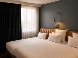 A hotel room with a large bed, a headboard, and a wall-mounted lamp. - 1.75 Paris Le Charme (Paris)