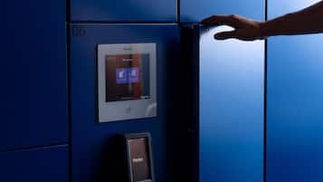 A hand interacting with a digital lock on a blue elevator door.