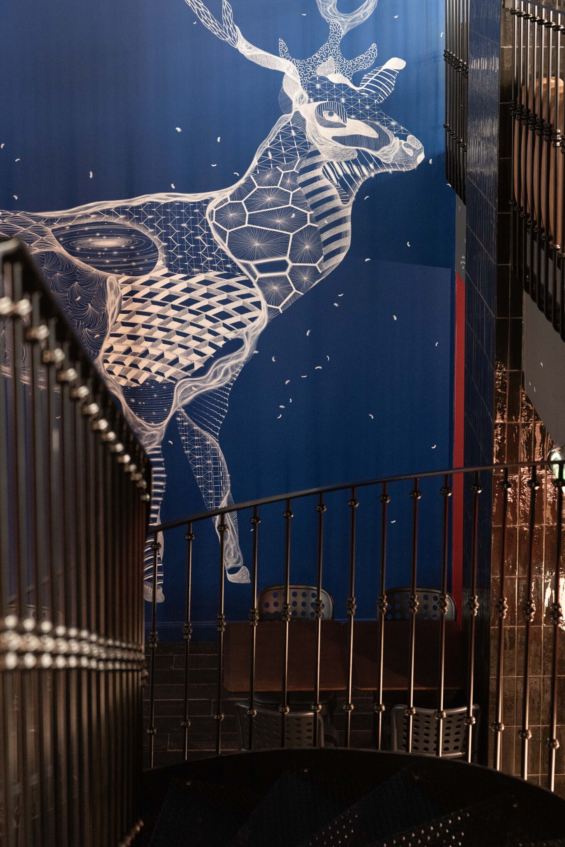 A staircase with metal railings and a decorative wall featuring a geometric pattern.
