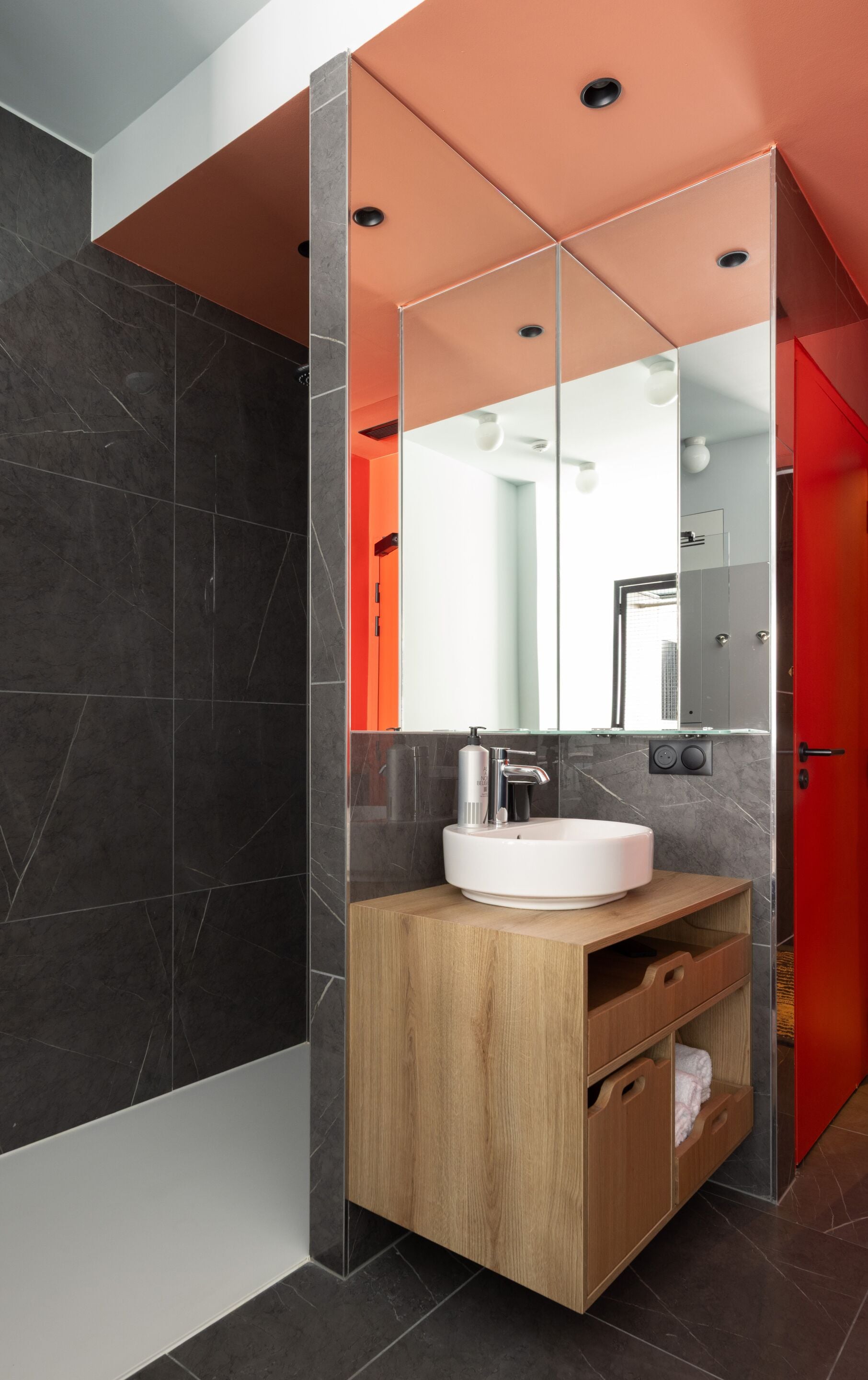 Une salle de bain moderne avec un meuble-lavabo en bois, un lavabo blanc et un grand miroir.