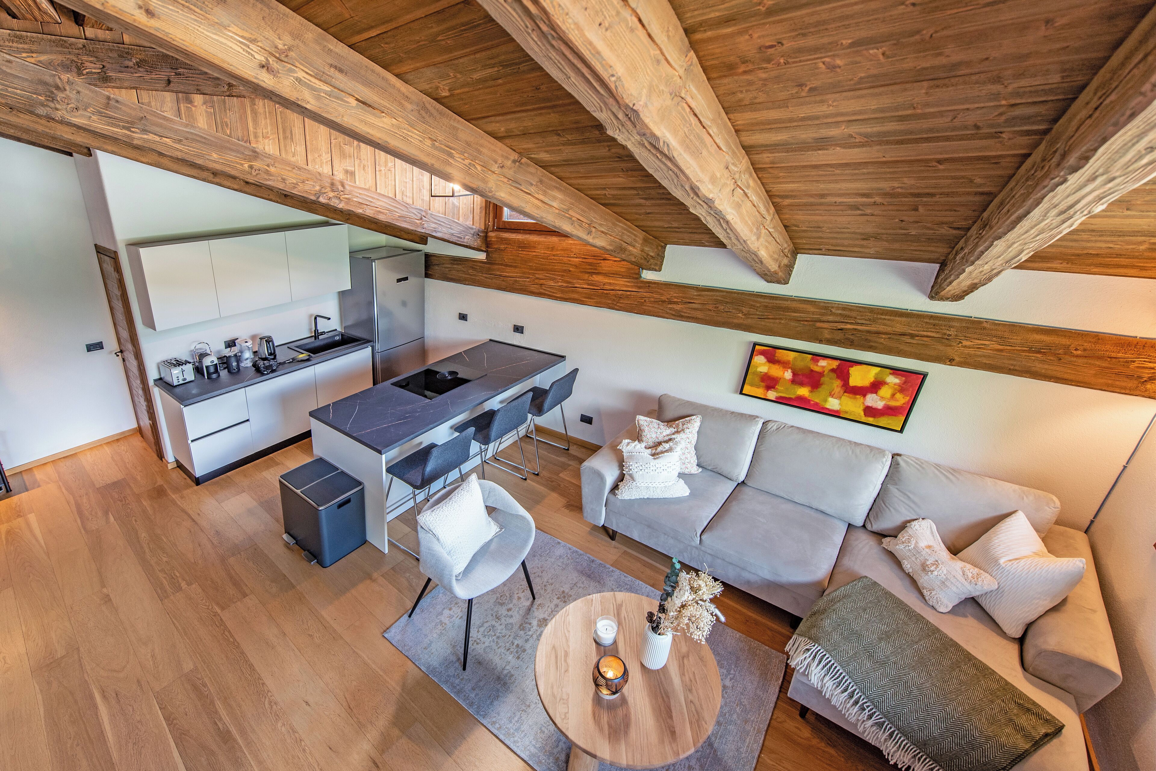 A modern kitchen with a dining area, a sofa, and a coffee table.