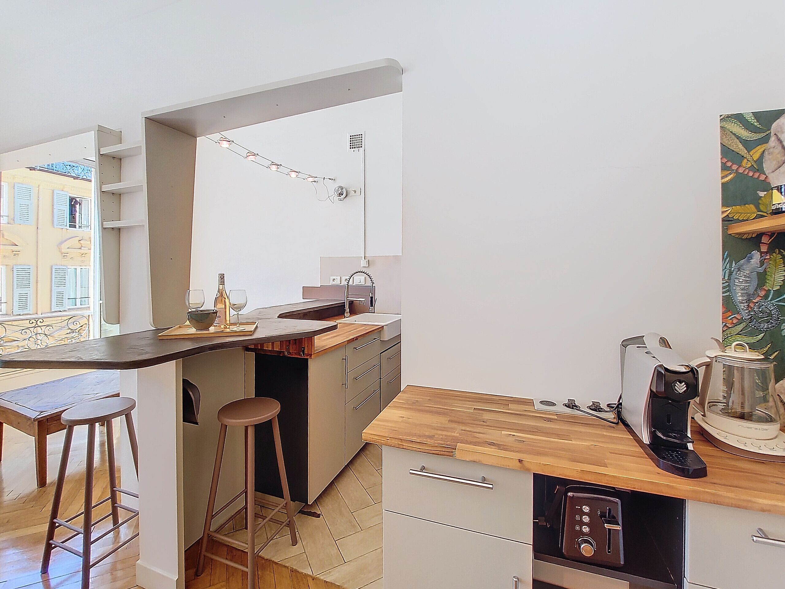 A compact kitchen with a wooden countertop, a coffee machine, and a sink.