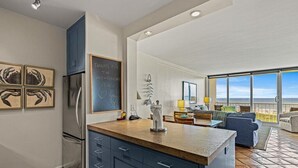 Eine moderne Küche mit einer großen Kochinsel, einem Kühlschrank und einer Tafel mit einer Notiz.