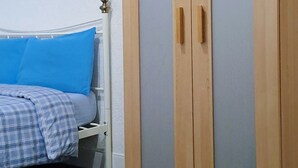 A bedroom with a bed, a wardrobe, and a carpeted floor. - MC Suites (Newcastle-upon-Tyne)