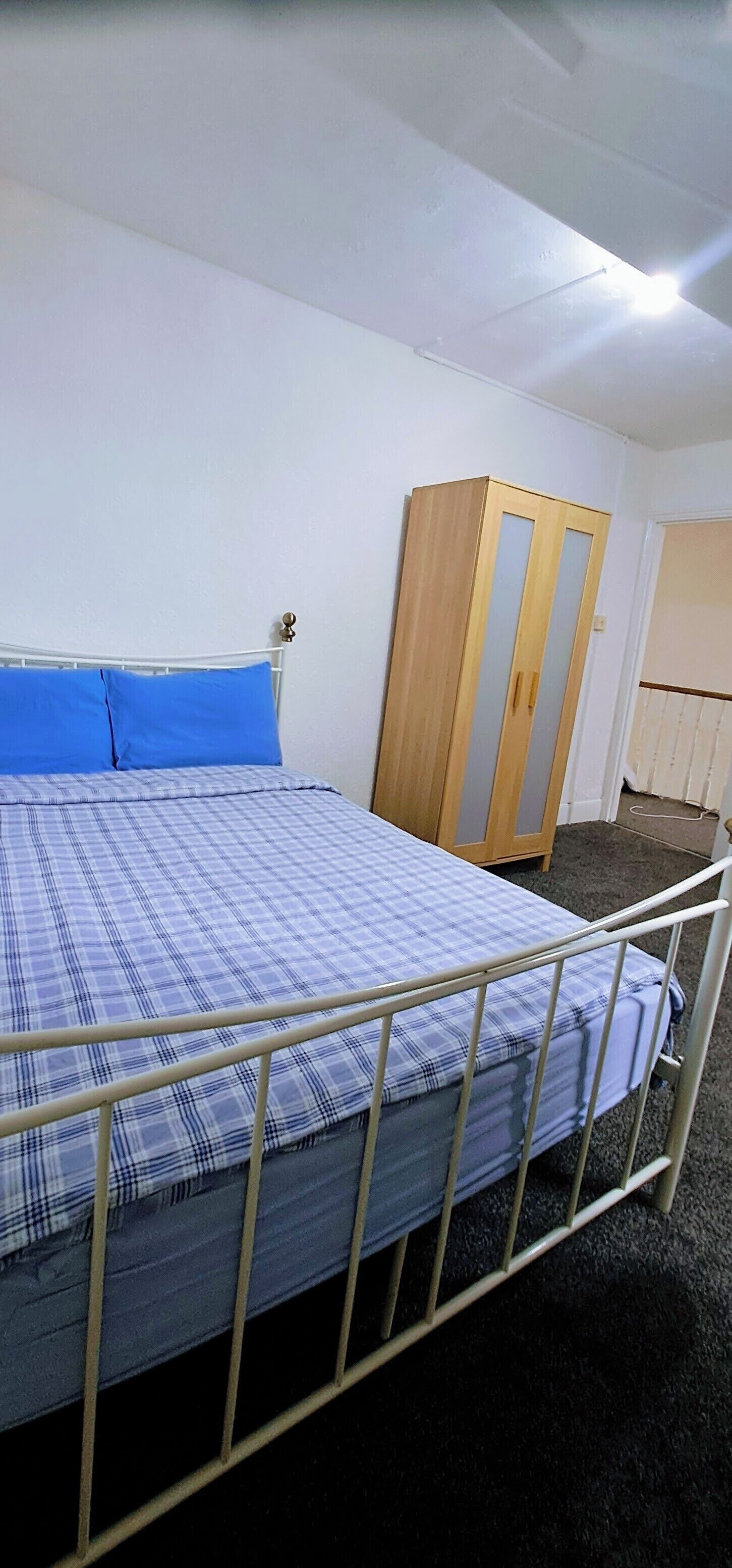 Une pièce comprenant un lit, une armoire et une porte.