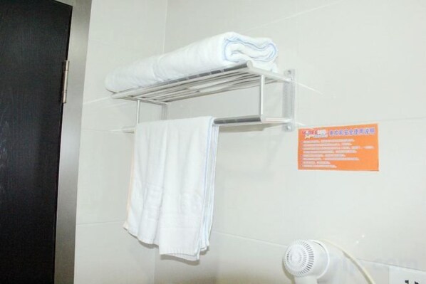 A bathroom with a towel rack holding two towels, a fan, and a sign on the wall. - Yantong Hotel (Nantong)