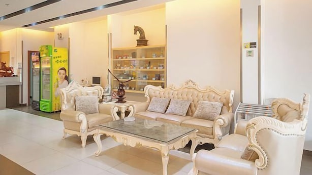 Um hall amplo com um conjunto de sofá branco clássico, uma mesa de centro de vidro e uma escultura decorativa de cavalo.