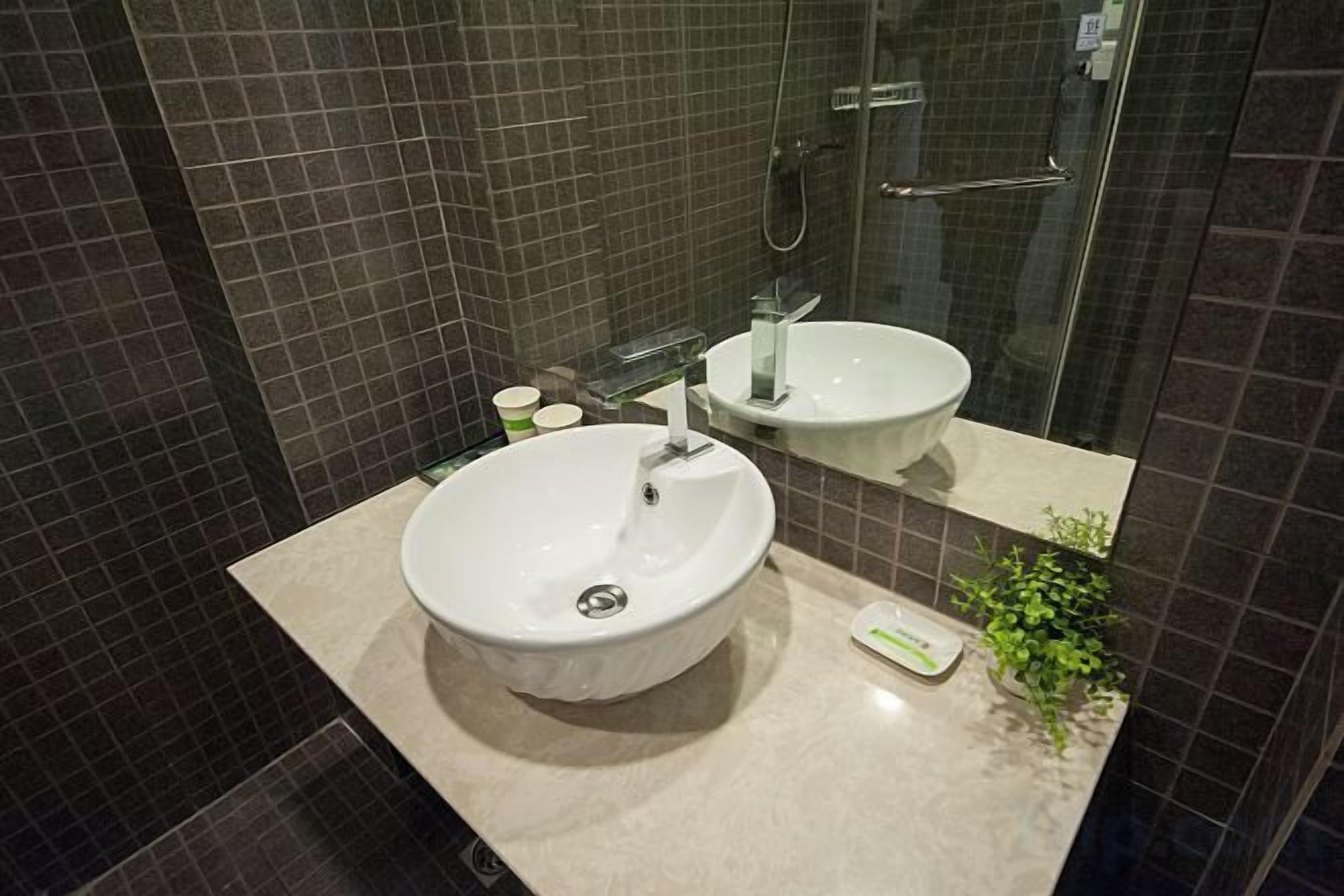 A bathroom with a white sink, a mirror, and a glass shower enclosure.