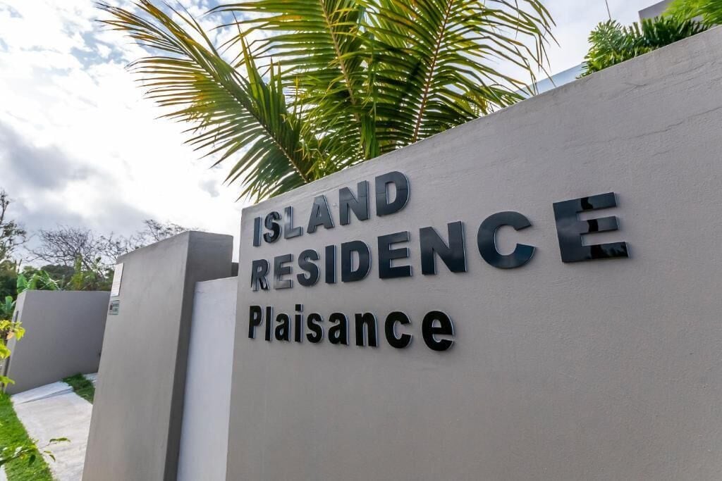 Un cartel que dice 'Island Residence' con la palabra 'Plaisance' debajo.