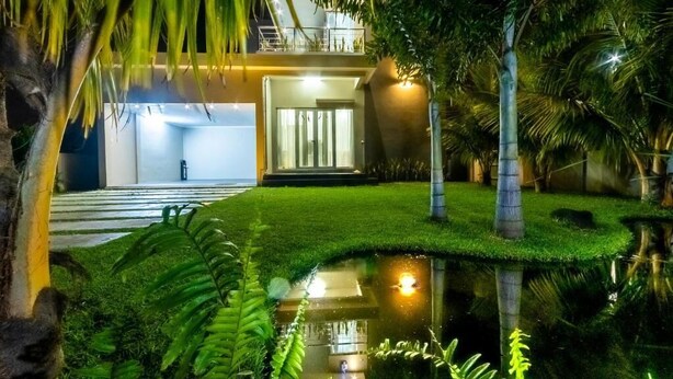 A modern house with a well-maintained lawn, a small pond, and a balcony overlooking the garden. - ISLAND RESIDENCE Plaisance - Mauritius - Villa with Private Pool (Island residence,Plaine Magnien)
