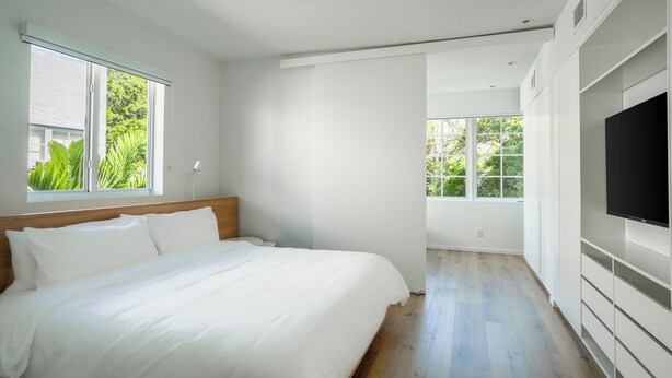 Camera da letto moderna con un letto grande, armadio a muro e televisore.
