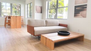 Un soggiorno moderno con un divano, un tavolino e una zona pranzo con sedie.