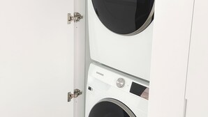 Una parete bianca con due lavatrici Samsung affiancate.