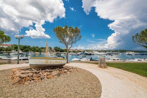 A boat named "Kalimmo" docked at a marina with boats and a clear sky.