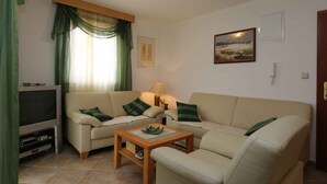 A living room with a sofa, a coffee table, a TV, and a lamp.