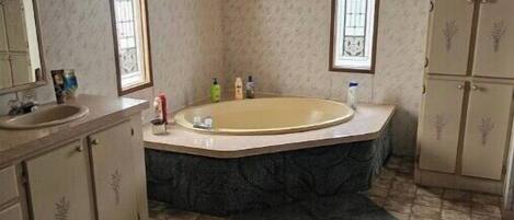 Un baño con bañera, lavamanos y tocador.